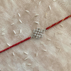 An Eternity Knot Silver Rakhi With Red Moli Thread
